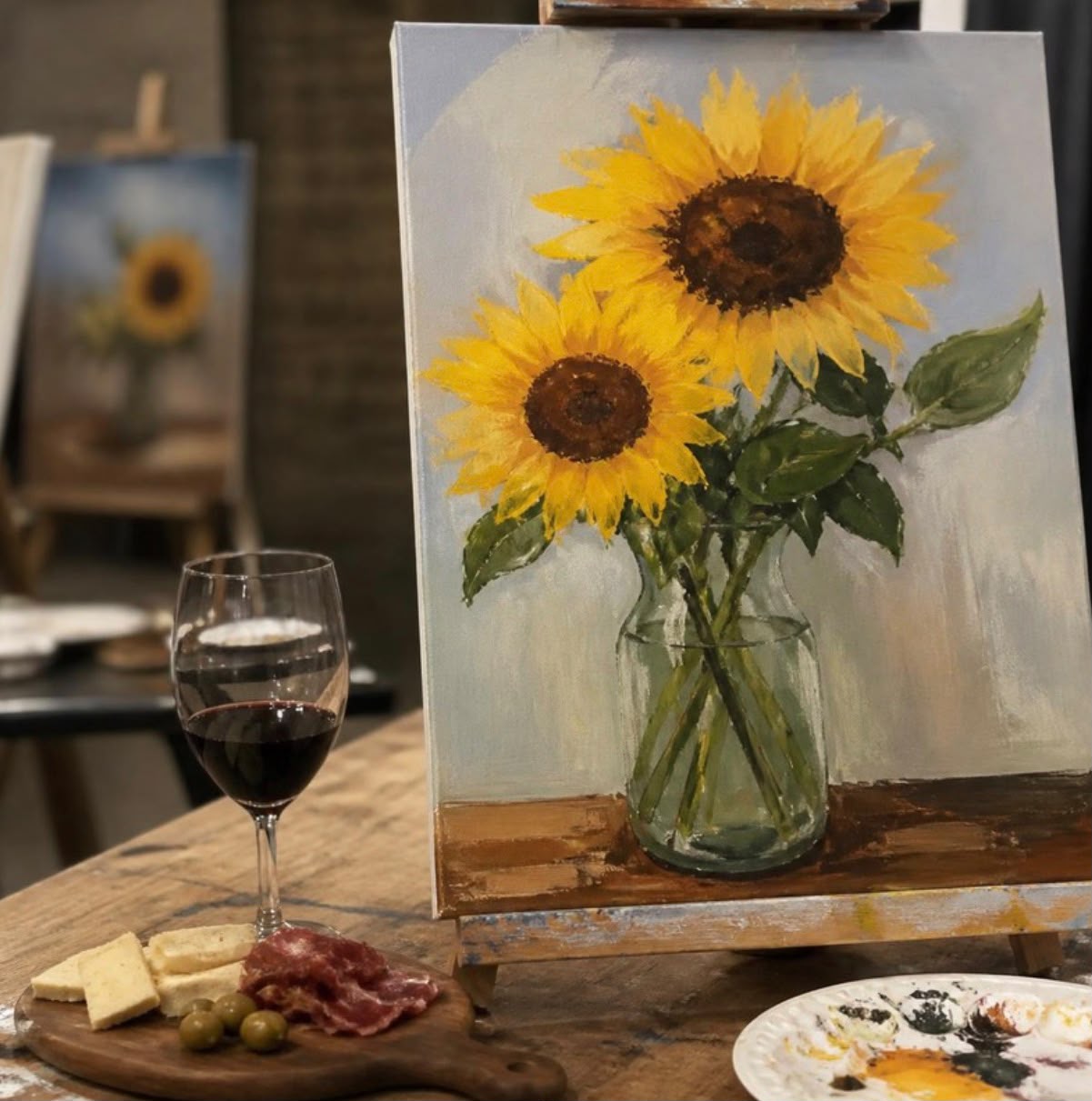 Copas de vino junto a lienzos y pinturas acrílicas en Yutori Espacio Creativo, A Coruña